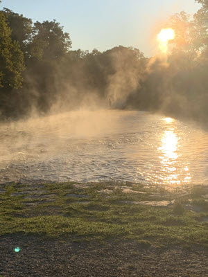 the mist rising over a river in the morning